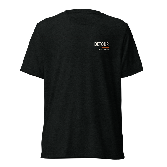 Cutline Soft Tee in Solid Black Triblend, Bella + Canvas 3413, with small left-chest Detour graphic. Genuine Printful garment mockup.